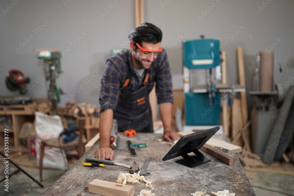 Contemporary Carpenter Working, Portrait of modern carpenter making wood furniture while working in joinery lit by sunlight with factory background on small business concept, copy space Contemporary Carpenter Working, Portrait of modern carpenter making wood furniture while working in joinery lit by sunlight with factory background on small business concept, copy space