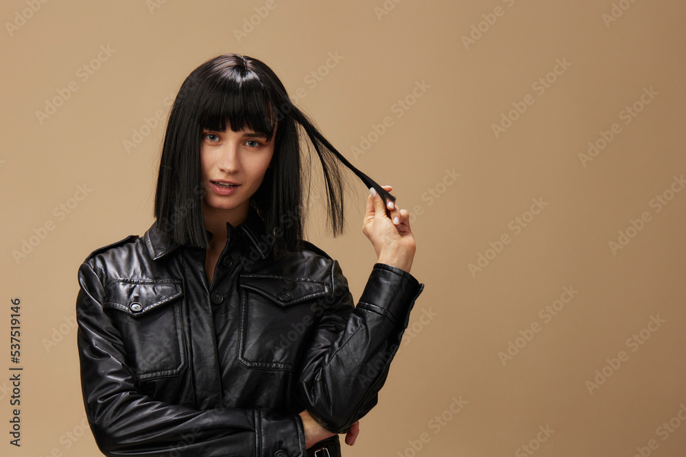 Self confident pretty adorable brunet lady in leather jacket flirting at camera posing isolated on pastel beige studio background. Copy space Banner Offer. Pulp Fiction concept. Fashion Cinema Self confident pretty adorable brunet lady in leather jacket flirting at camera posing isolated on pastel beige studio background. Copy space Banner Offer. Pulp Fiction concept. Fashion Cinema