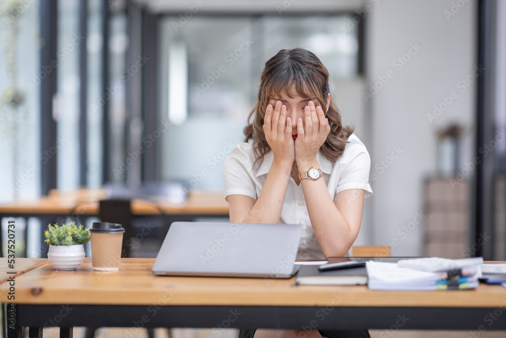 Young Business Asian women are stressed while working on laptop, Tired asian businesswoman with headache at office, feeling sick at work copy space in workplace an home office. Young Business Asian women are stressed while working on laptop, Tired asian businesswoman with headache at office, feeling sick at work copy space in workplace an home office.
