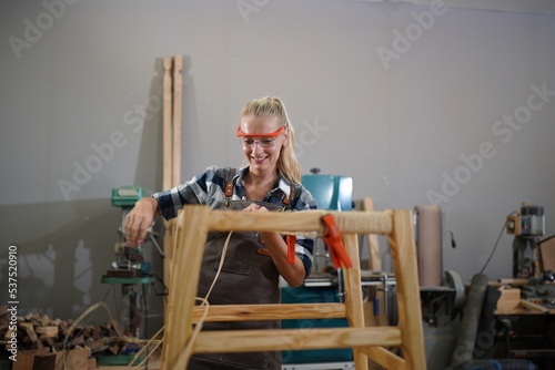 Contemporary Carpenter Working, Portrait of modern carpenter making wood furniture while working in joinery lit by sunlight with factory background on small business concept, copy space