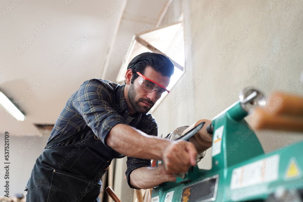 Contemporary Carpenter Working, Portrait of modern carpenter making wood furniture while working in joinery lit by sunlight with factory background on small business concept, copy space Contemporary Carpenter Working, Portrait of modern carpenter making wood furniture while working in joinery lit by sunlight with factory background on small business concept, copy space