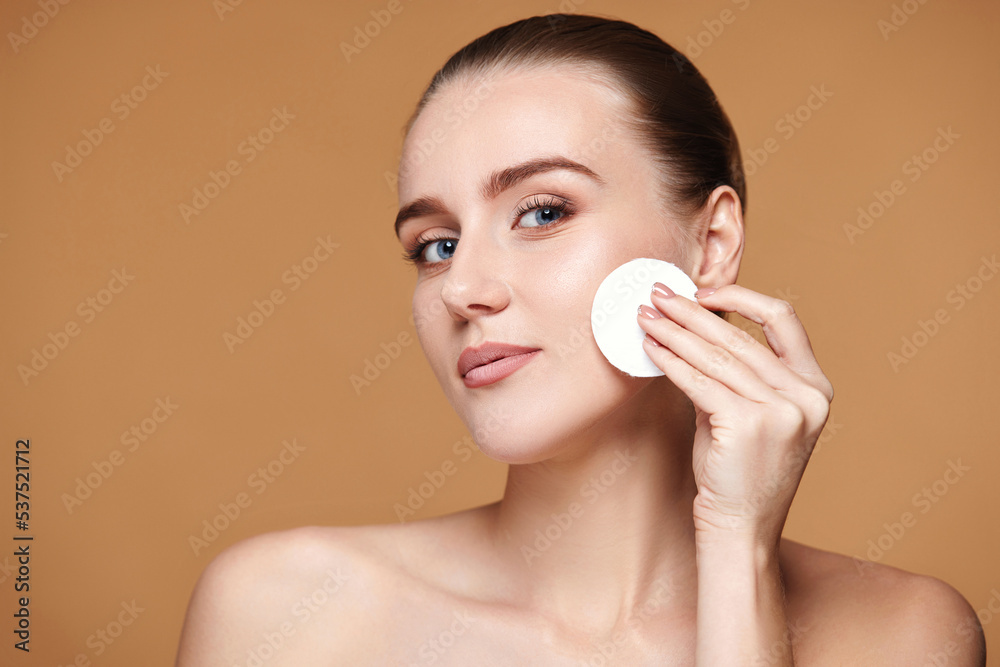 woman holding white cotton pad with micellar water woman holding white cotton pad with micellar water