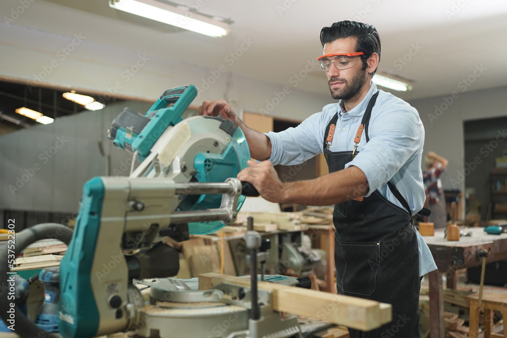 Contemporary Carpenter Working, Portrait of modern carpenter making wood furniture while working in joinery lit by sunlight with factory background on small business concept, copy space