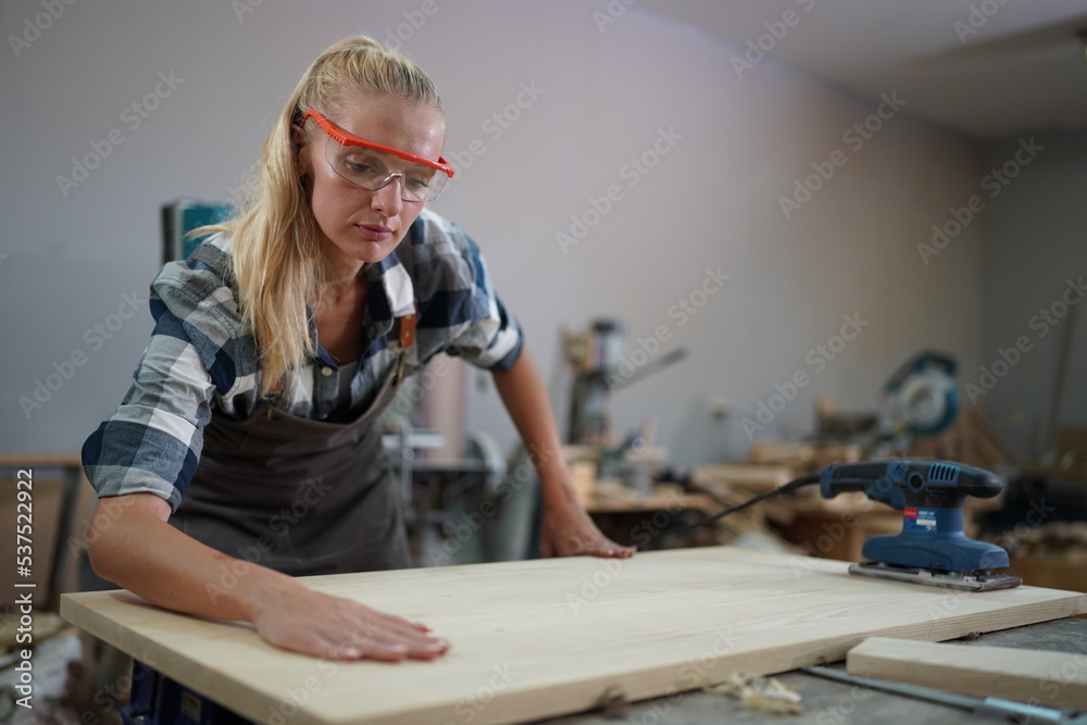Contemporary Carpenter Working, Portrait of modern carpenter making wood furniture while working in joinery lit by sunlight with factory background on small business concept, copy space Contemporary Carpenter Working, Portrait of modern carpenter making wood furniture while working in joinery lit by sunlight with factory background on small business concept, copy space