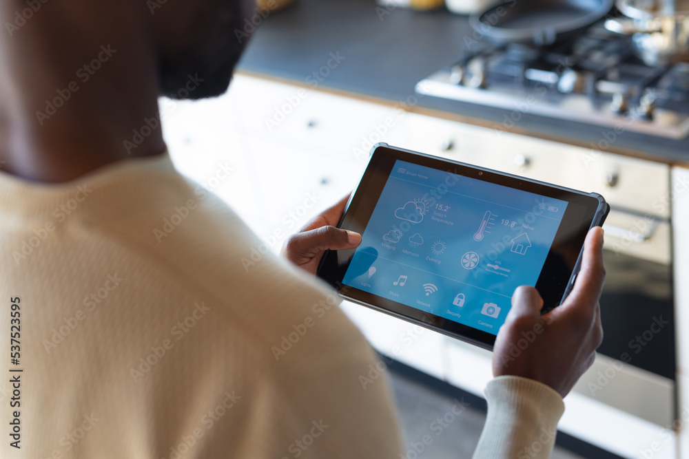 Midsection of african american man using tablet with weather forecast Midsection of african american man using tablet with weather forecast