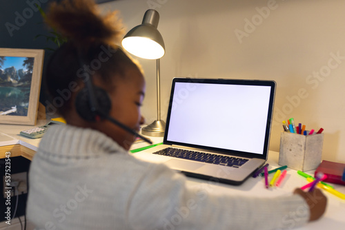 Happy african american girl having video call, using laptop with copy space