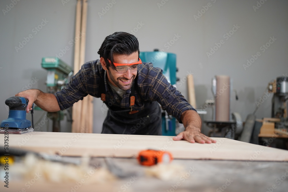 Contemporary Carpenter Working, Portrait of modern carpenter making wood furniture while working in joinery lit by sunlight with factory background on small business concept, copy space Contemporary Carpenter Working, Portrait of modern carpenter making wood furniture while working in joinery lit by sunlight with factory background on small business concept, copy space