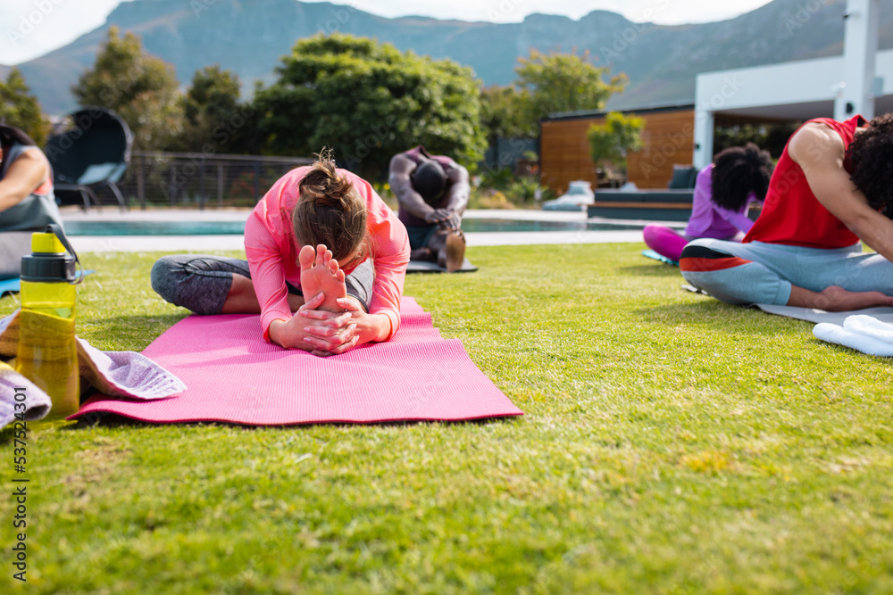 Happy diverse friends practicing yoga and stretching in garden Happy diverse friends practicing yoga and stretching in garden