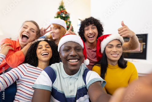 Portrait of happy diverse friends with santa hats at christmas