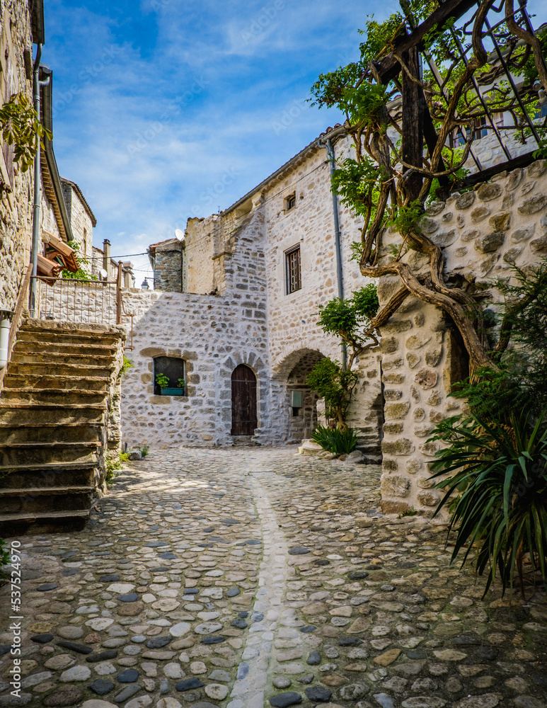 View on the narrow but beautiful cobblestone street of the medieval village of Lanas, in the south of France (Ardeche)