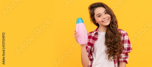 beauty. kid use shower gel. happy teen girl with shampoo bottle. shampooing hair in salon. Banner of child girl hair care  studio poster header with copy space.
