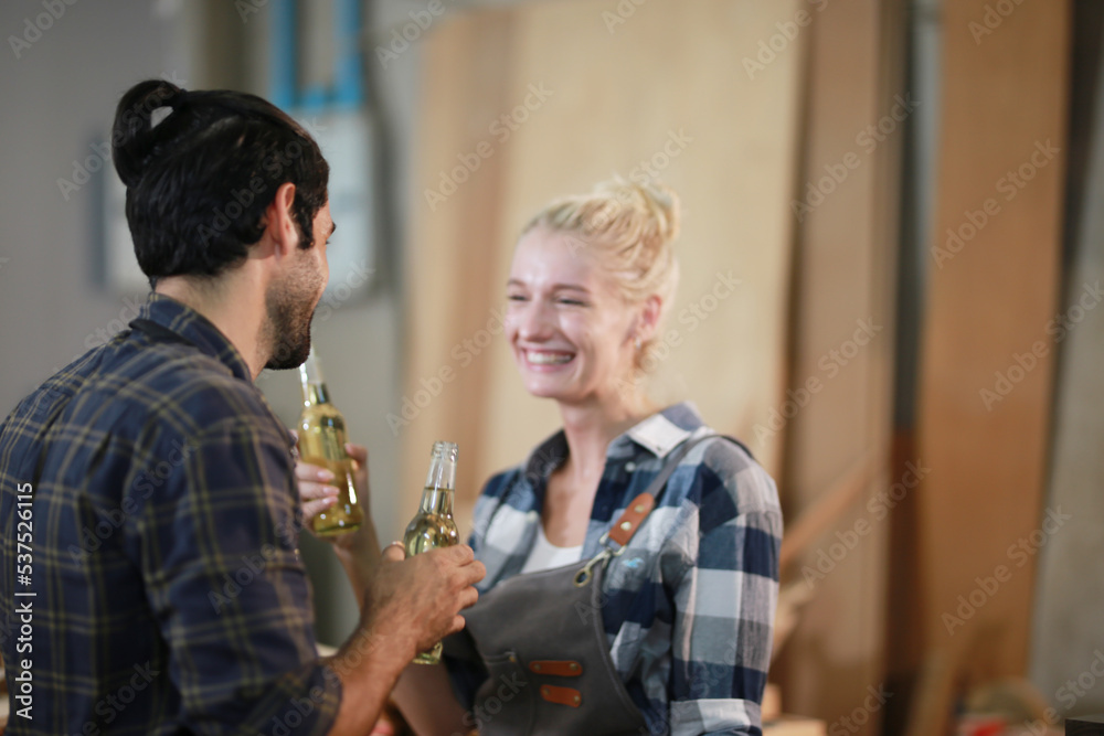 Happy Couple Carpenters have celeabate with a drink bottle after work of Assembling Furniture, Small business in wood DIY workplace office background Happy Couple Carpenters have celeabate with a drink bottle after work of Assembling Furniture, Small business in wood DIY workplace office background