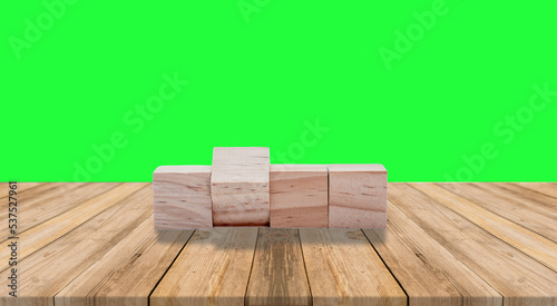 Blank Wooden cube on  empty table top on of green background. 
