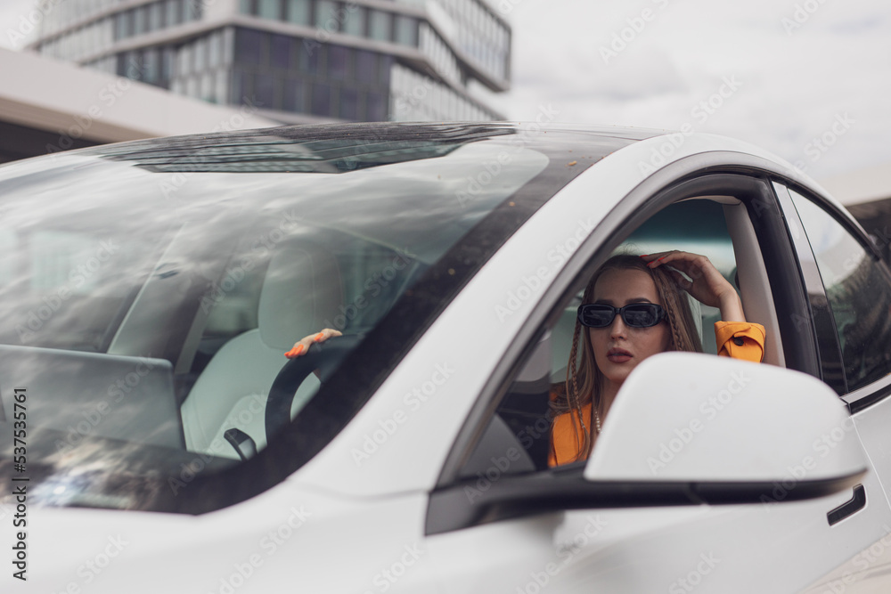 Schöne Junge Frau bei Elektro Auto Fahren durch die Grüne umweltfreie Stadt Schöne Junge Frau bei Elektro Auto Fahren durch die Grüne umweltfreie Stadt