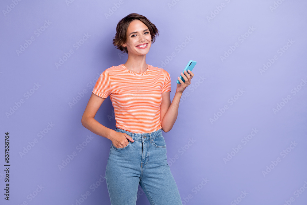 Photo of positive satisfied lady hand hold telephone enjoy new cool purchase device empty space isolated on purple color background Photo of positive satisfied lady hand hold telephone enjoy new cool purchase device empty space isolated on purple color background
