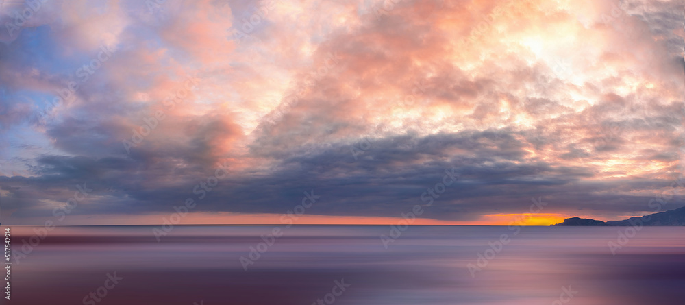 Very beautiful widescreen atmospheric natural seascape of sunset with textured sky in purple tones.