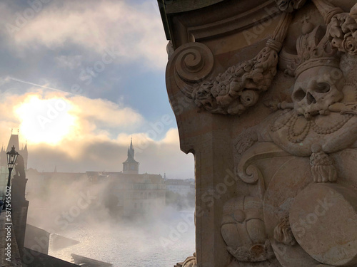 Canvas Print Behind a skull carved from stone the sun burns off the mist over the ancient cit