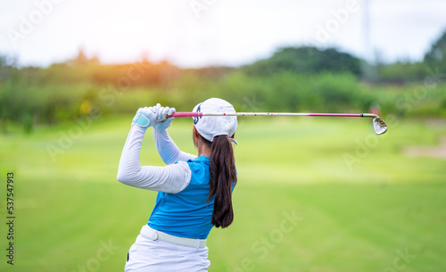 Professional woman golfer teeing golf in golf tournament competition at golf course for winner. 