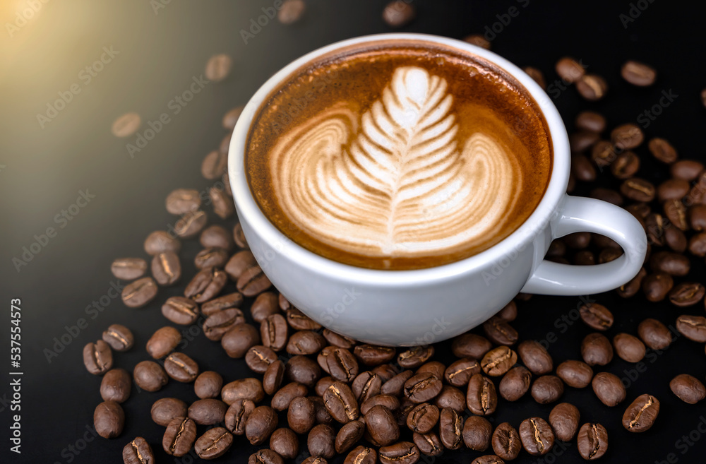 Obraz premium Top view coffee latte art in white caramic cup with coffee beans , Coffee Art Concept