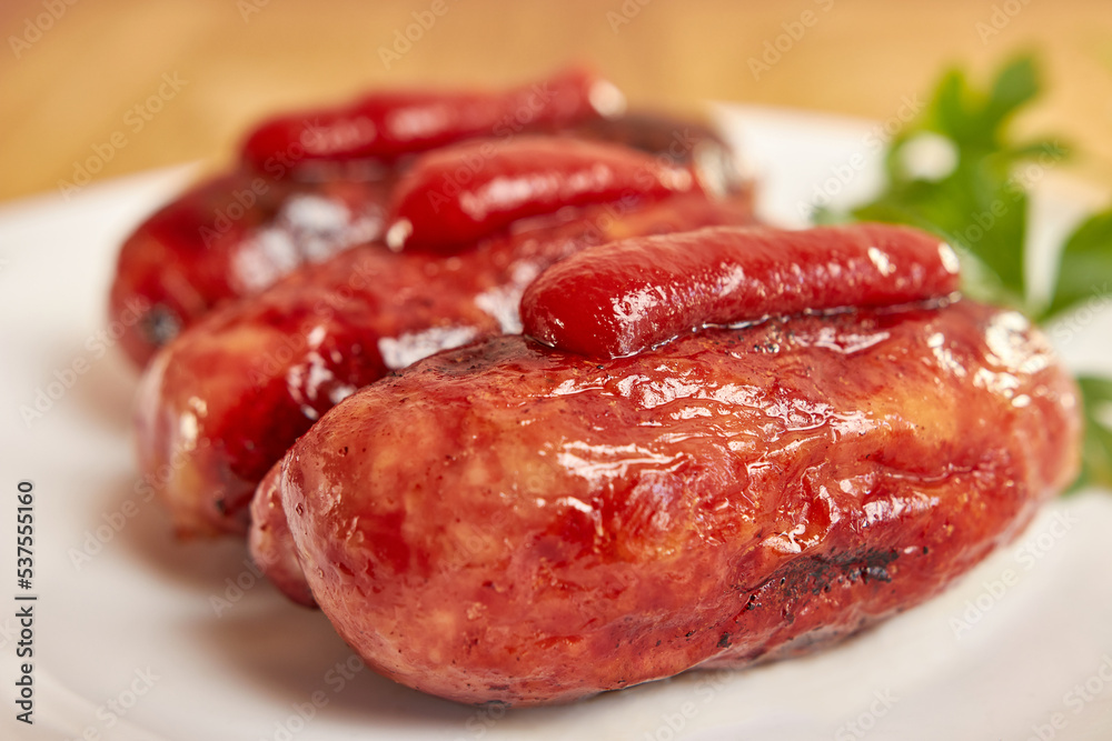 Fried sausages with ketchup on a white plate.