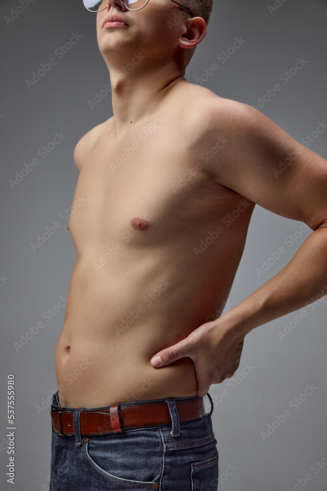 Cropped image of male body isolated over grey studio background. Weight-loss, body-positivity, sportive lifestyle