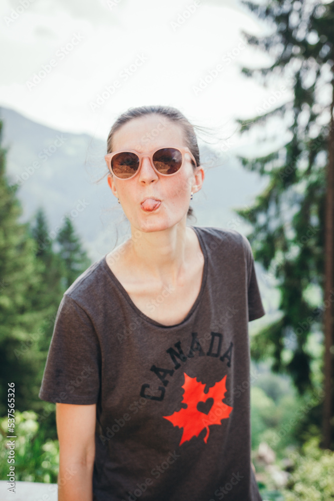 portrait of a person in a park. The girl shows her tongue portrait of a person in a park. The girl shows her tongue