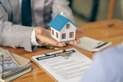Home agents talk to new homebuyers and offer good interest rates and calculate clients on mortgage financing to help them decide on real estate ideas with insurance.
