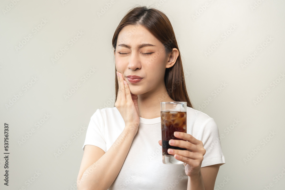 Health asian young woman touching her mouth, expression, suffering from toothache, decay or sensitivity cavity molar tooth or inflammation drink cold, sparkling water at home.Sensitive teeth people. Health asian young woman touching her mouth, expression, suffering from toothache, decay or sensitivity cavity molar tooth or inflammation drink cold, sparkling water at home.Sensitive teeth people.