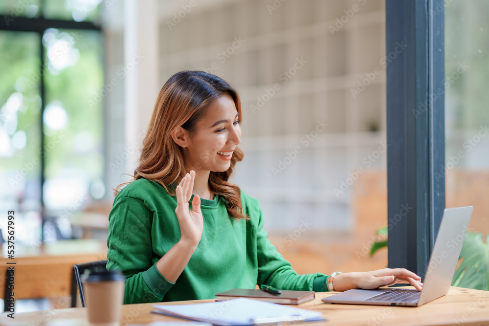 Beautiful young Asian woman college student is video chatting with her classmates using laptop, smiling faces and gestures happily studying. Beautiful young Asian woman college student is video chatting with her classmates using laptop, smiling faces and gestures happily studying.