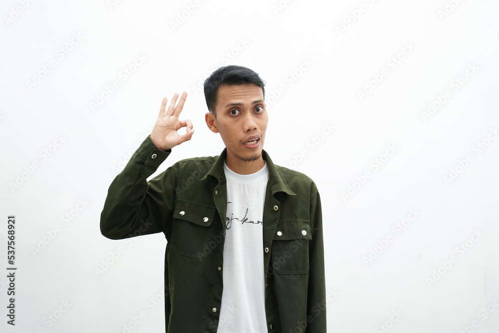 Asian man wearing casual green shirt giving ok sign gesture. isolated white background Asian man wearing casual green shirt giving ok sign gesture. isolated white background