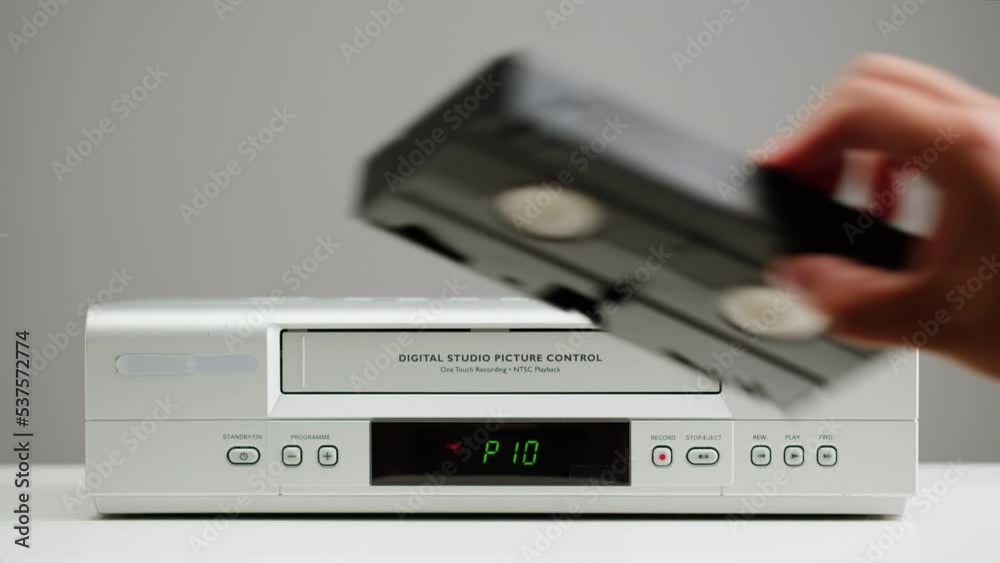 Old video recorder close-up, VHS. Retro player, vintage video cassette broadcasting on grey background, audio tape. Old video recorder close-up, VHS. Retro player, vintage video cassette broadcasting on grey background, audio tape.