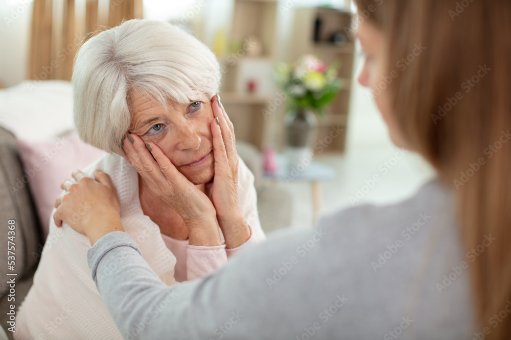 young woman talk with worried elderly mom young woman talk with worried elderly mom