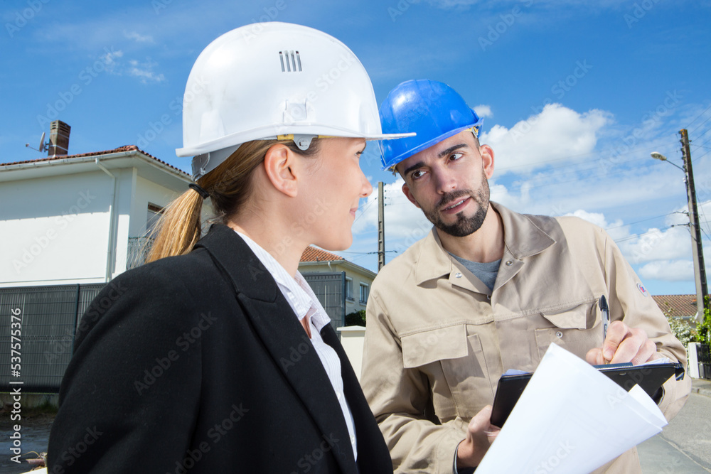 builder and female contractor talking during construction site builder and female contractor talking during construction site