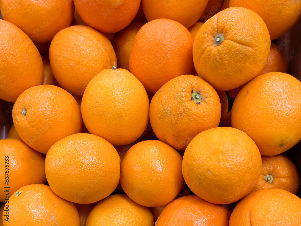 Pile of fresh navel oranges on display at grocery store market. Ripe citrus fruit. Pile of fresh navel oranges on display at grocery store market. Ripe citrus fruit.