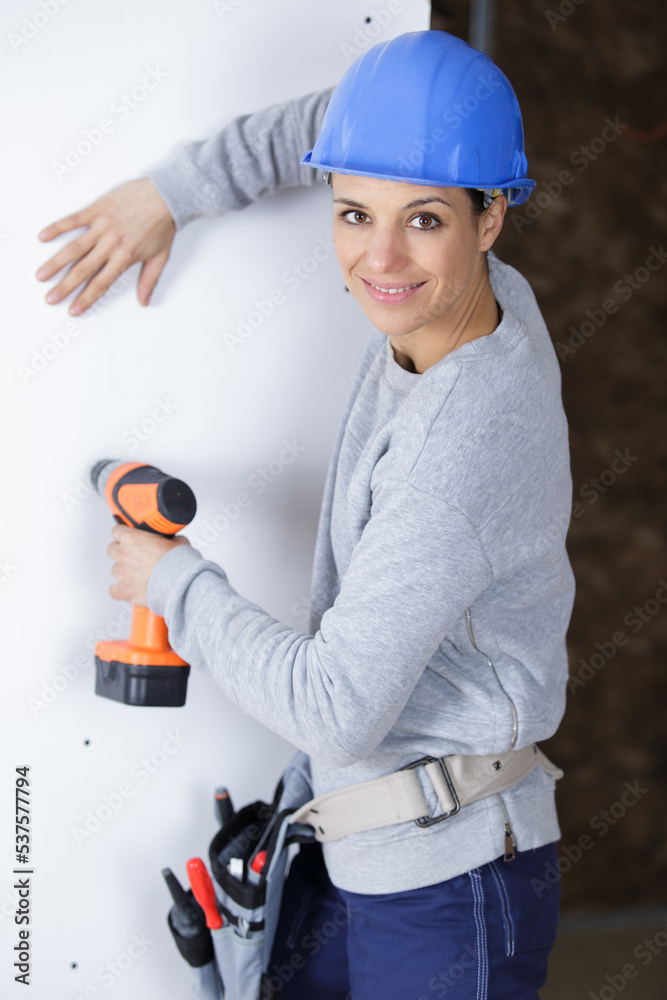 happy woman is drilling a wall happy woman is drilling a wall