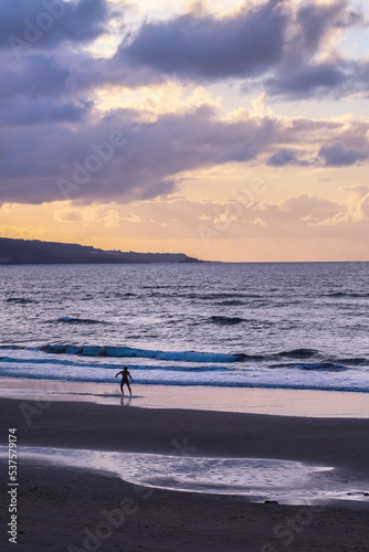 Man exercising surf at sunset on the Las Canteras Beach in Las Palmas