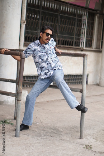 mans wearing white shirt posing infront of old vintage building