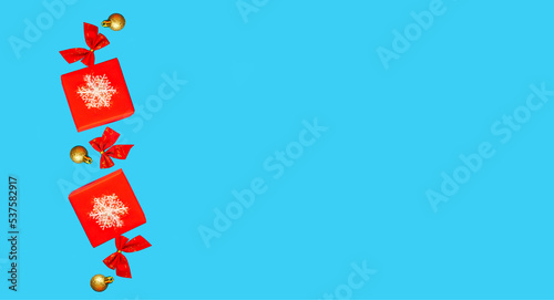 Red gift boxes with white snowflakes are floating on a blue background. Christmas decorations levitate on a blue background. Isolate. Place for text. Banner. New Year, Christmas - holiday concept.