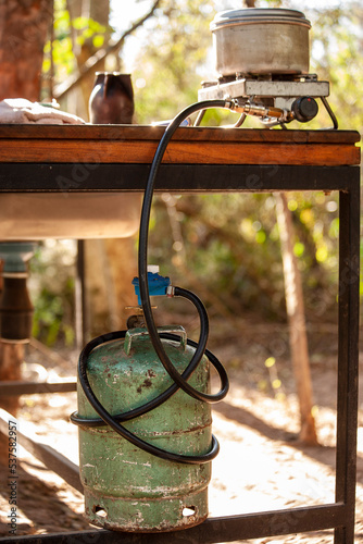 Stove on a table connected to a gas cylinder in a camp in 