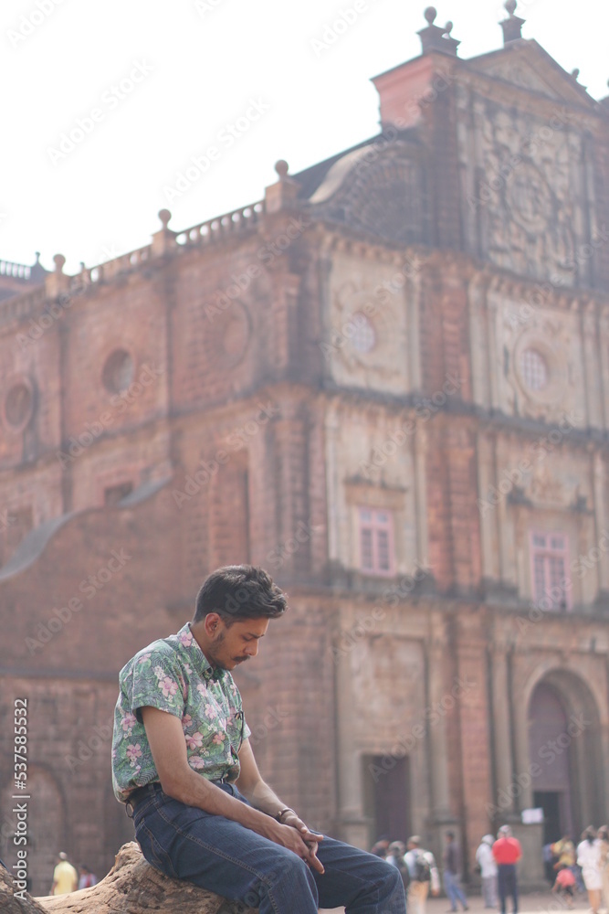 man posing infront of old goa chruch