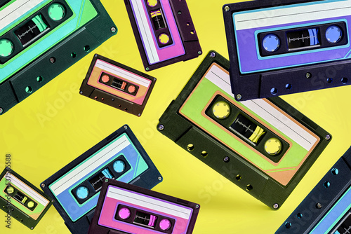 Pop music style attributes eighties, retro old school concept. Multicolored audio cassette levitates on a bright blue creative background.