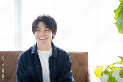 リビングのソファーに座りリラックスする20代男性