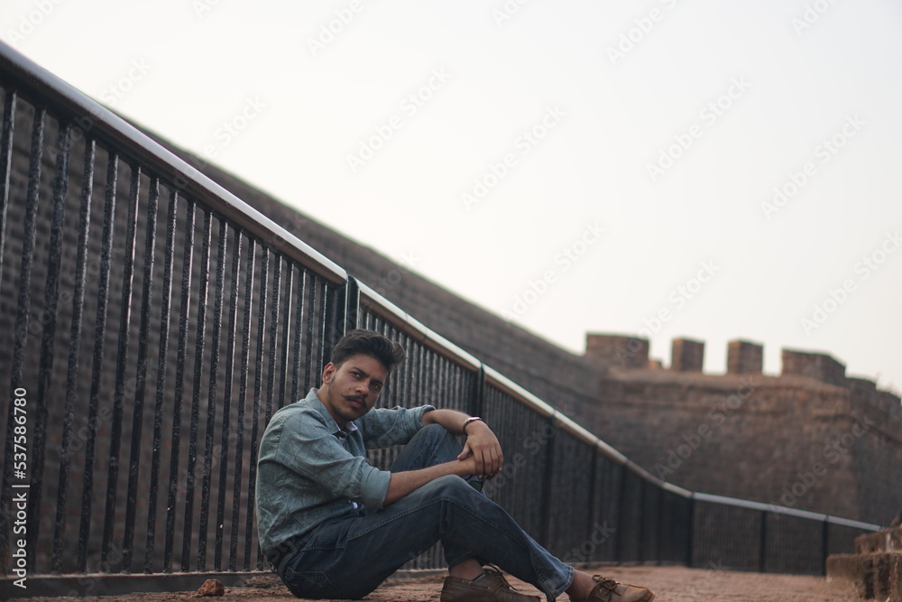 man sitting on old building roadside man sitting on old building roadside