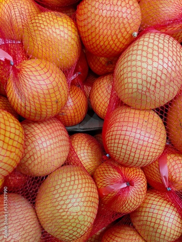 fresh ripe grapefruits packaged in packaging nets on the supermarket counter