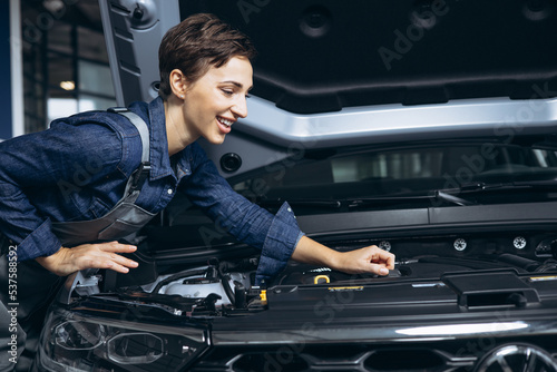 Young woman car mechanic checking car at car service © Petro