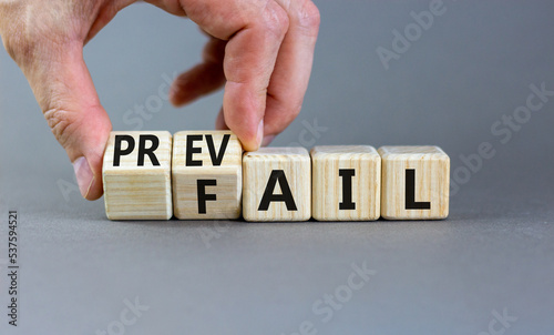 Prevail or fail symbol. Concept words Prevail or Fail on wooden cubes. Businessman hand. Beautiful grey table grey background. Business prevail or fail concept. Copy space.