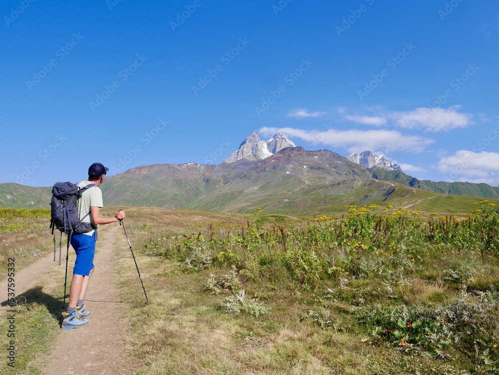 Man hiking to Koruldi lakes, beautiful view of Great Caucasus mountains close to Mestia in Upper Svaneti, Georgia.
