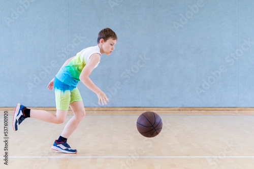 School kid playing basketball in a physical education lesson. Horizontal education poster, greeting cards, headers, website © Augustas Cetkauskas