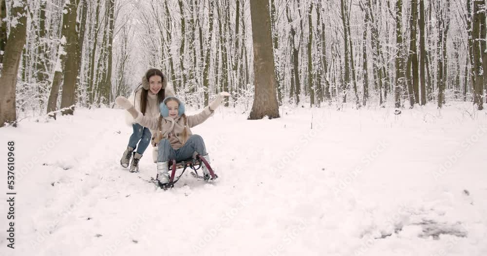 A woman is carrying a child on a sled