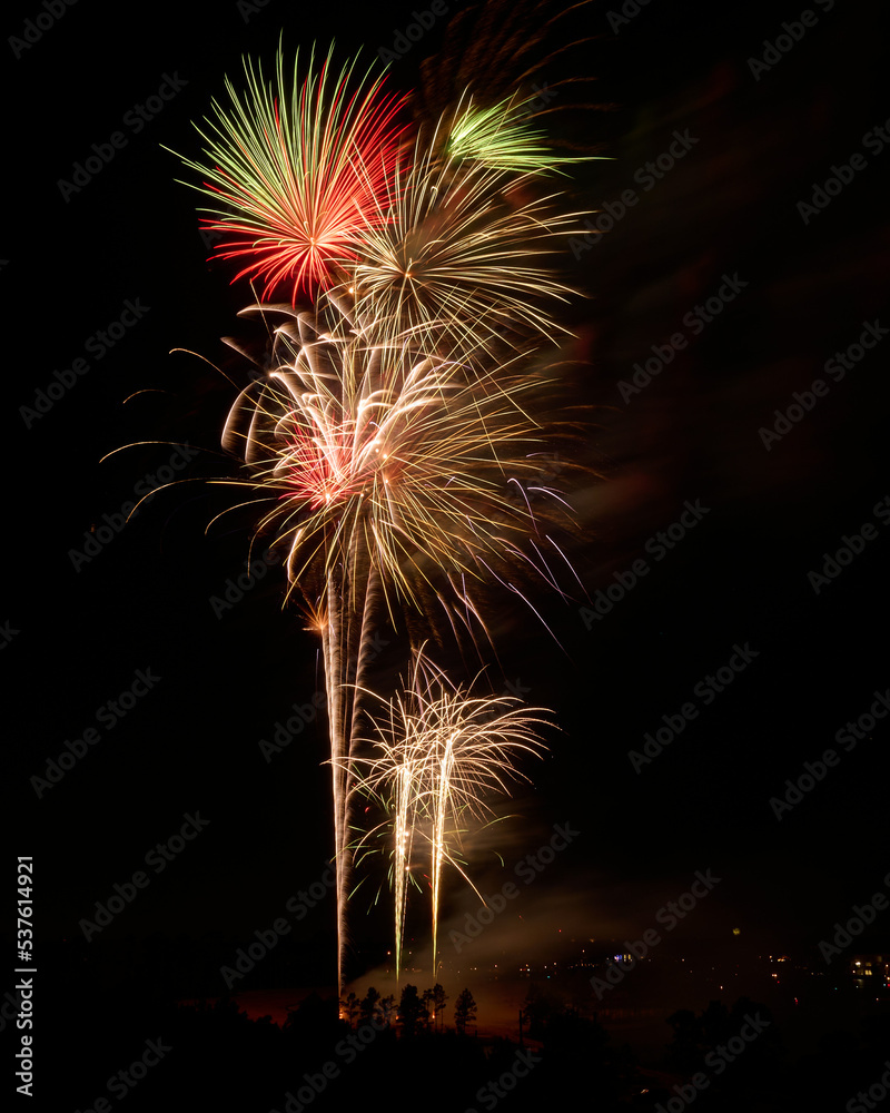 THE WOODLANDS, TEXAS, USA - July 2022: celebratory fireworks on July 4th on Lake Woodlands. Lots of spectators gathered to admire the show set on water. They watched from the Northshore park. THE WOODLANDS, TEXAS, USA - July 2022: celebratory fireworks on July 4th on Lake Woodlands. Lots of spectators gathered to admire the show set on water. They watched from the Northshore park.